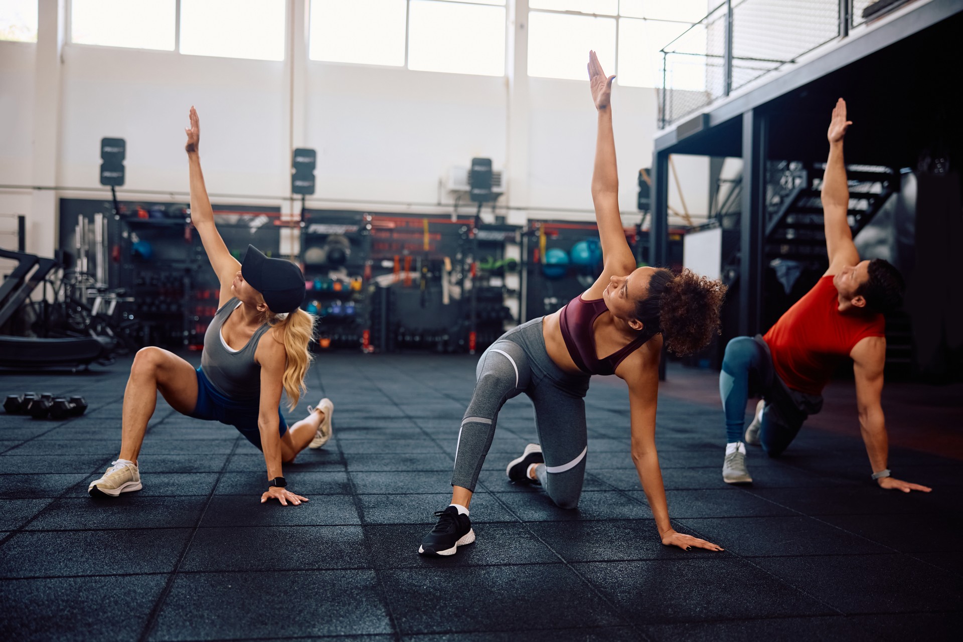 Group of athletes warming up while having sports training in health club.